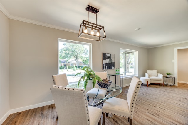 dining room with light hardwood / wood-style flooring and ornamental molding