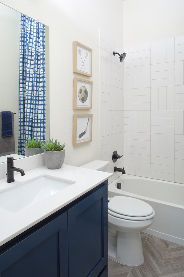 full bathroom featuring vanity, tiled shower / bath combo, and toilet