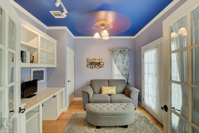 living area with french doors, plenty of natural light, light hardwood / wood-style floors, and crown molding