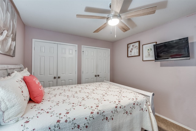 bedroom featuring ceiling fan, two closets, and carpet