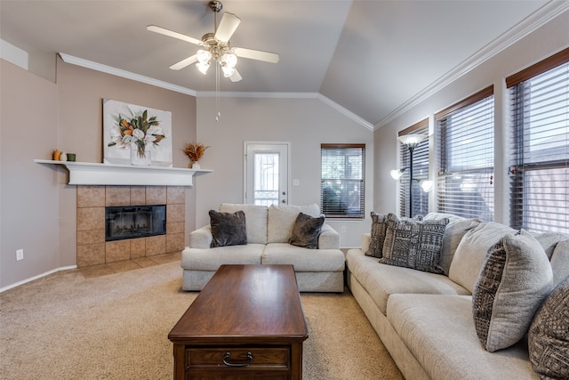 carpeted living room featuring vaulted ceiling, ceiling fan, a tile fireplace, and crown molding