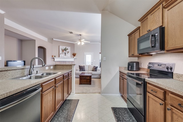 kitchen with appliances with stainless steel finishes, vaulted ceiling, ceiling fan, ornamental molding, and sink