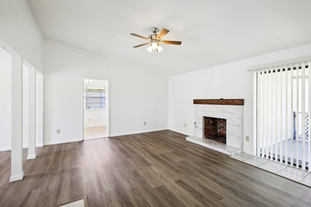 unfurnished living room featuring a fireplace, vaulted ceiling, dark wood-type flooring, and ceiling fan