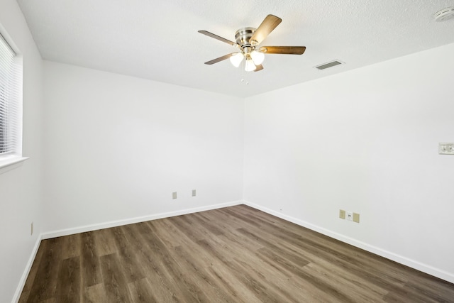 spare room with a textured ceiling, dark hardwood / wood-style flooring, and ceiling fan