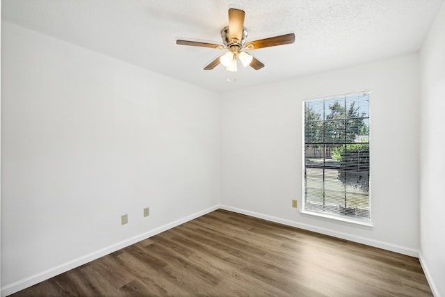 empty room with a textured ceiling, dark hardwood / wood-style floors, and ceiling fan