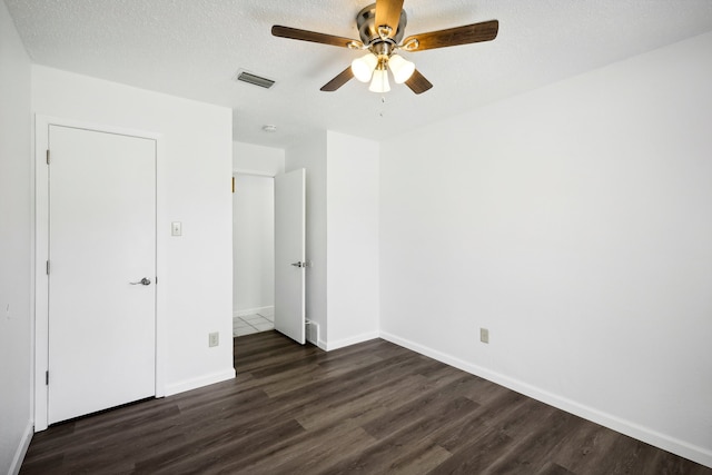 unfurnished bedroom with ceiling fan, dark wood-type flooring, and a textured ceiling