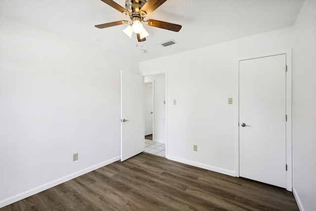 unfurnished room featuring a textured ceiling, dark hardwood / wood-style flooring, and ceiling fan