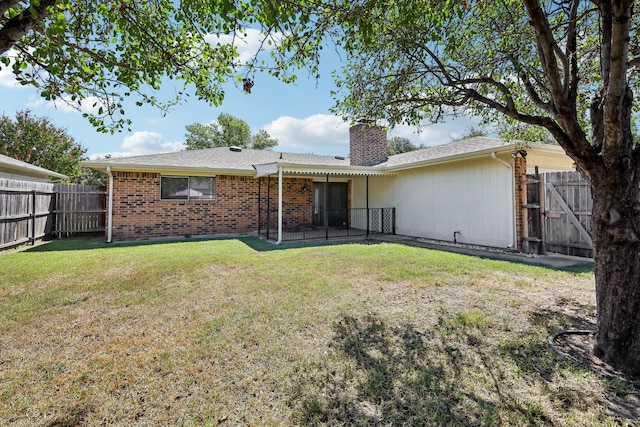 rear view of property with a lawn