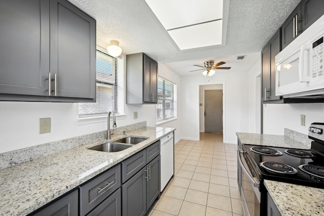 kitchen featuring ceiling fan, light tile patterned flooring, sink, white appliances, and a textured ceiling