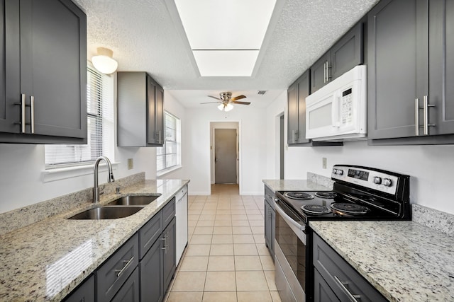 kitchen featuring ceiling fan, light tile patterned flooring, sink, white appliances, and light stone countertops