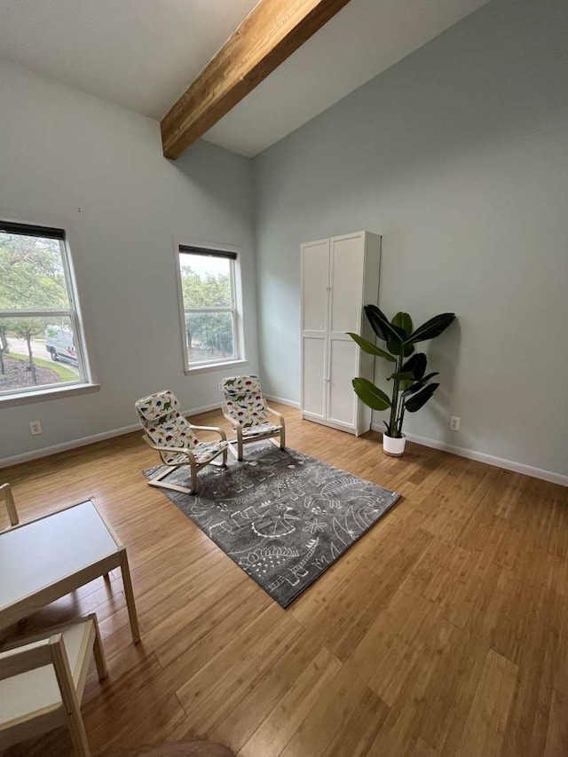 living area with lofted ceiling with beams and light hardwood / wood-style flooring