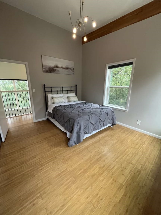 bedroom featuring an inviting chandelier and light hardwood / wood-style floors