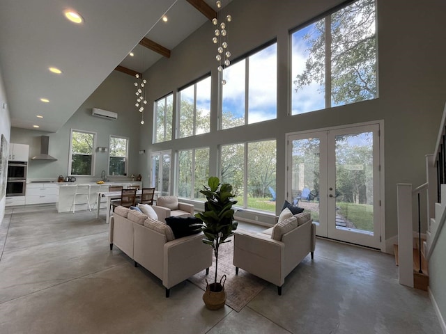 living room featuring an AC wall unit, a towering ceiling, and concrete floors