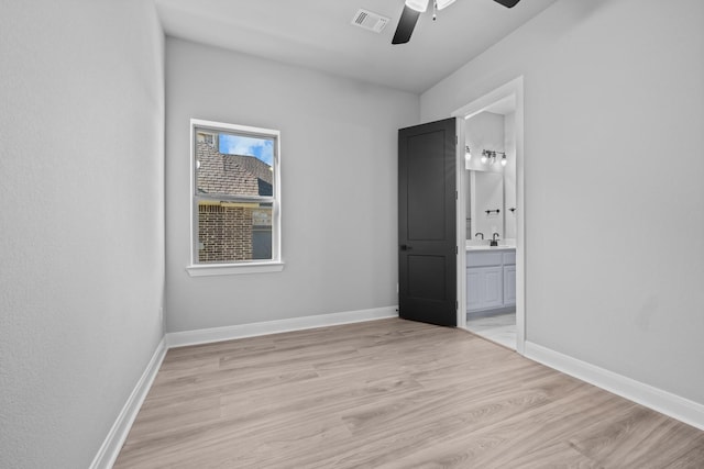 unfurnished room with sink, ceiling fan, and light wood-type flooring