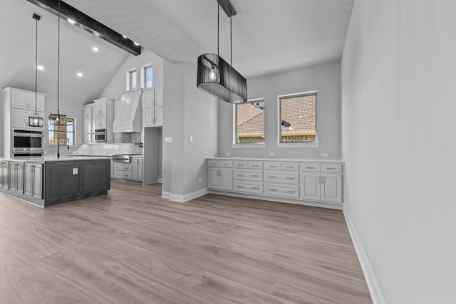 kitchen with a wealth of natural light, white cabinetry, a center island, and decorative light fixtures