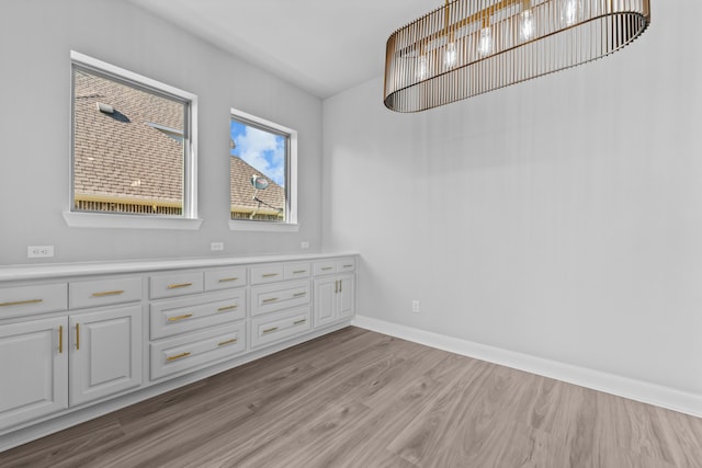 unfurnished dining area featuring light wood-type flooring