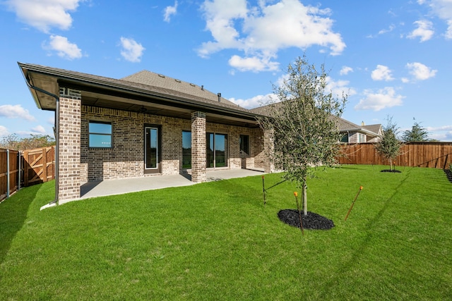 rear view of property with a yard and a patio area