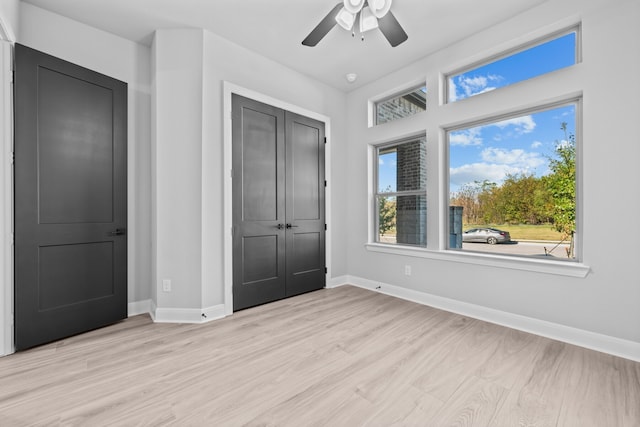 unfurnished bedroom with light hardwood / wood-style floors, a closet, and ceiling fan