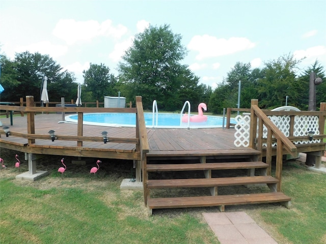 view of pool featuring a deck and a lawn