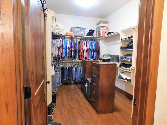 walk in closet with dark hardwood / wood-style floors