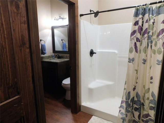 bathroom featuring vanity, a shower with curtain, hardwood / wood-style flooring, and toilet