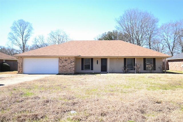 single story home with a garage, a front yard, brick siding, and driveway