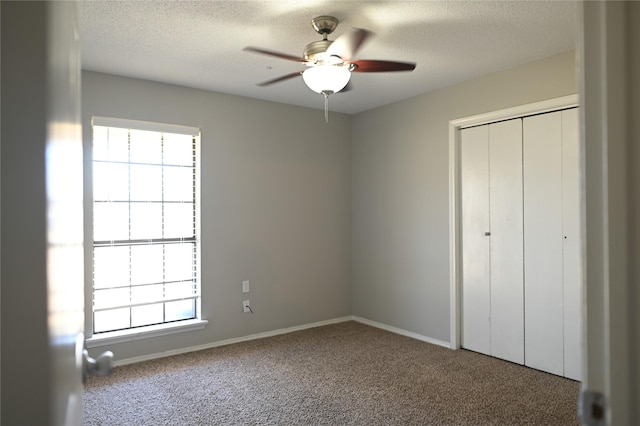 unfurnished bedroom with a textured ceiling, a closet, and carpet flooring