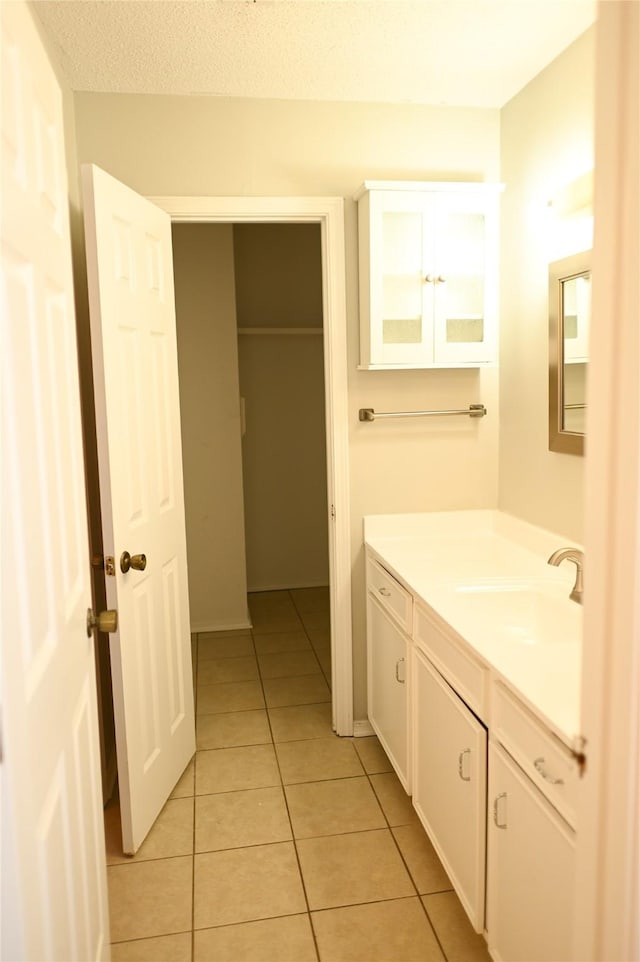 bathroom featuring a textured ceiling, tile patterned flooring, and vanity