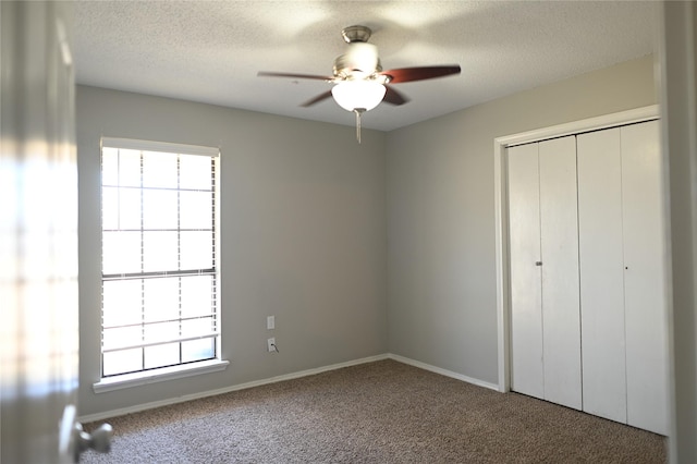 unfurnished bedroom with carpet, multiple windows, and a textured ceiling