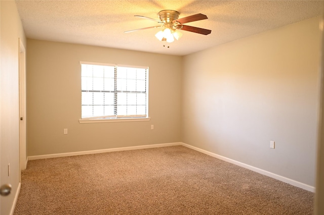 carpeted empty room featuring a textured ceiling, a ceiling fan, and baseboards