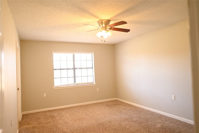 carpeted spare room with ceiling fan, a textured ceiling, and baseboards