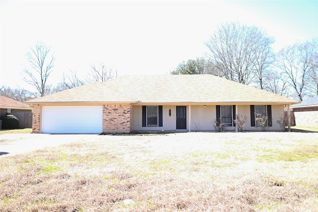 single story home with driveway, a front lawn, an attached garage, and brick siding