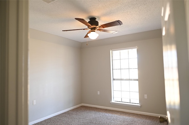 empty room with ceiling fan, carpet floors, a textured ceiling, and baseboards