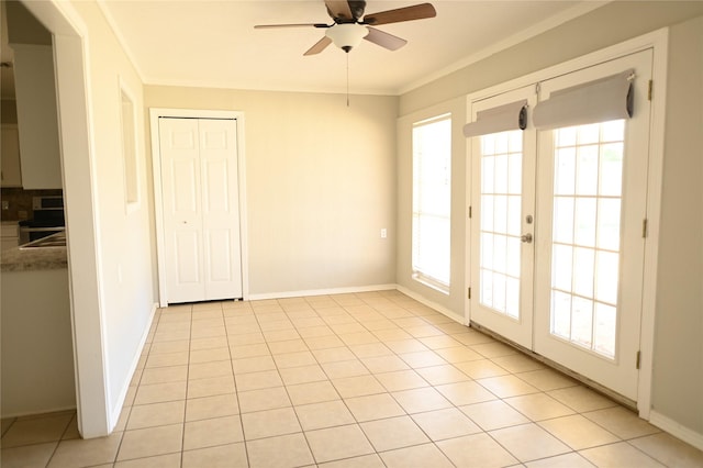 unfurnished room with a ceiling fan, light tile patterned flooring, a wealth of natural light, and crown molding