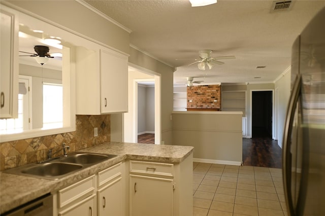 kitchen featuring ornamental molding, freestanding refrigerator, a sink, and dishwashing machine