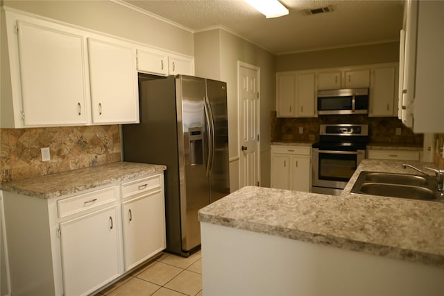 kitchen featuring light tile patterned floors, a sink, visible vents, white cabinetry, and appliances with stainless steel finishes