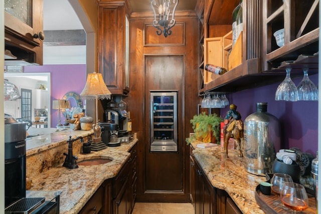 kitchen featuring crown molding, light stone countertops, sink, and wine cooler