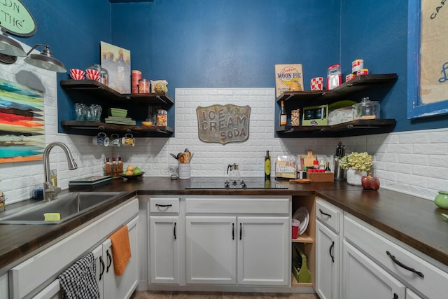 kitchen with decorative backsplash, sink, and white cabinets