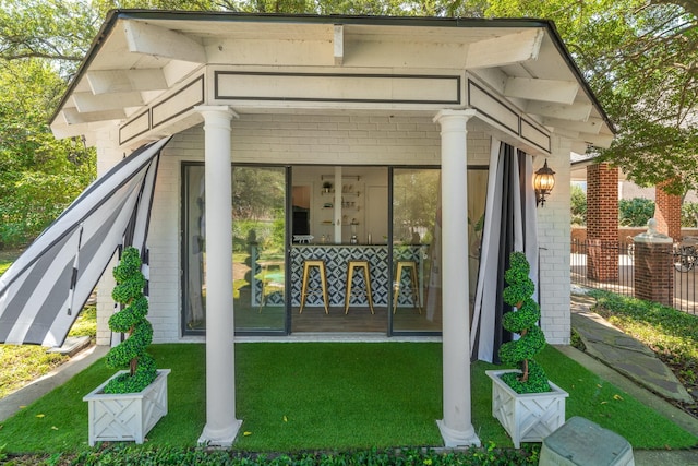 back of property featuring a lawn and a sunroom