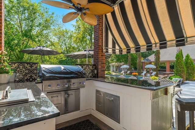 view of patio / terrace with a bar, an outdoor kitchen, and area for grilling