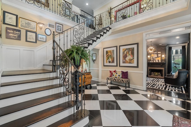 stairway featuring crown molding and a high ceiling