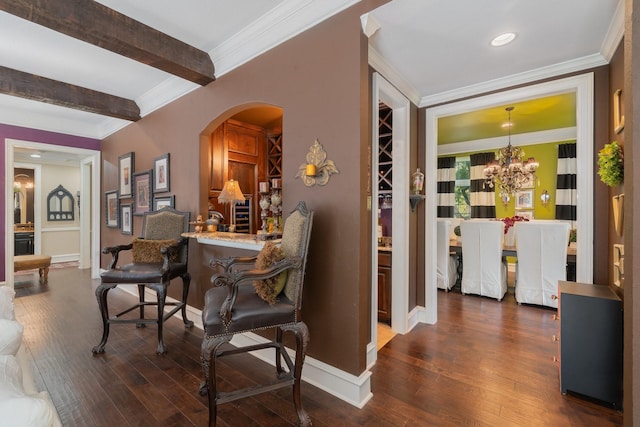 interior space with beamed ceiling, dark hardwood / wood-style flooring, crown molding, and an inviting chandelier