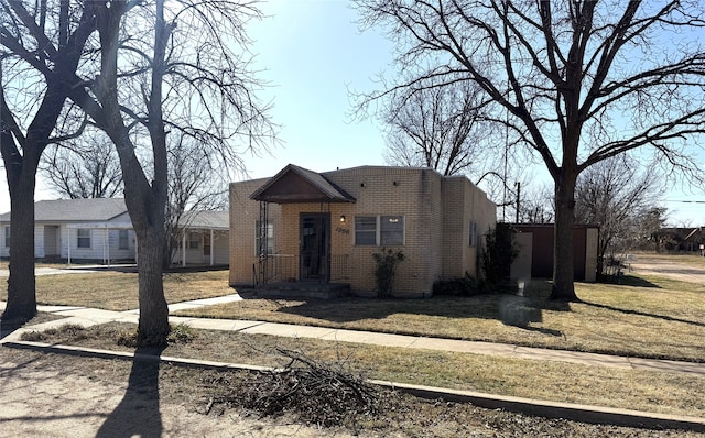 view of front facade with brick siding and a front yard