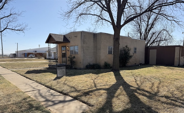 view of home's exterior with a lawn and brick siding