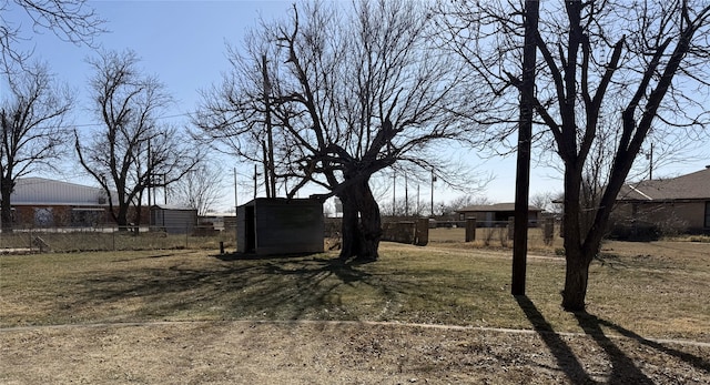 view of yard featuring an outbuilding, a shed, and fence