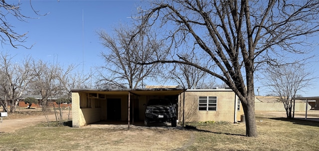 view of outbuilding with an attached carport and dirt driveway