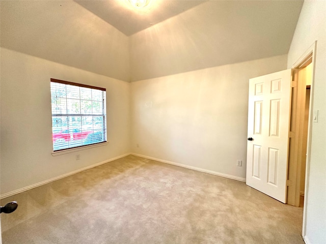 carpeted empty room with lofted ceiling