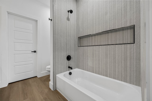 bathroom featuring hardwood / wood-style flooring, toilet, and shower / bathtub combination