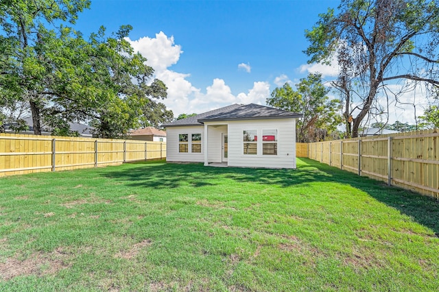 rear view of property with a lawn