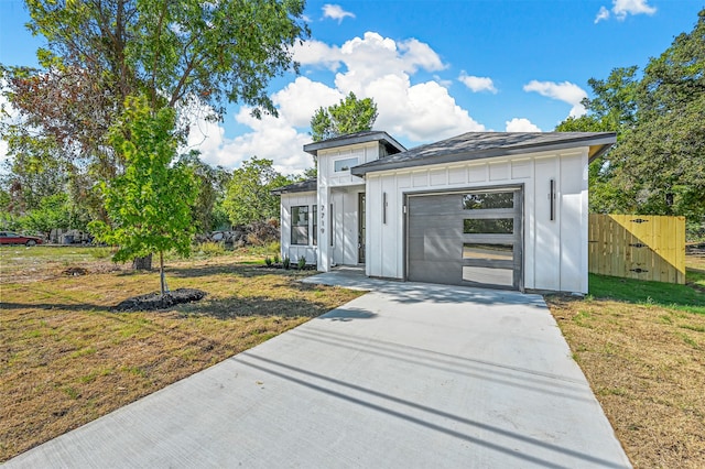 view of front of property with a garage and a front lawn